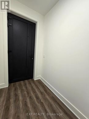 St. Catharines (Oakdale) townhouse for rent - A black door is in a white room with wood flooring.