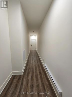 St. Catharines (Oakdale) townhouse for rent - A long hallway with wood flooring and white walls.