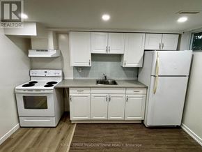 Newmarket (Huron Heights-Leslie Valley) apartment for rent - A white kitchen with wooden floors and white appliances.