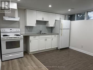 Newmarket (Huron Heights-Leslie Valley) apartment for rent - A white kitchen with a stove top oven and a refrigerator.