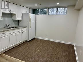 Newmarket (Huron Heights-Leslie Valley) apartment for rent - A kitchen with white cabinets and a white fridge.