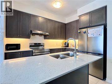 Kitchener townhouse for rent - A modern kitchen with dark brown cabinets and stainless steel appliances.