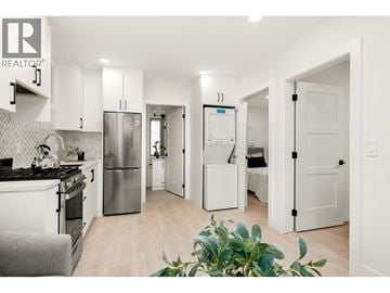 Vancouver apartment for rent - A modern kitchen with white cabinets and a stainless steel refrigerator.