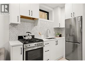 Vancouver apartment for rent - A modern kitchen with white cabinets and a stainless steel refrigerator.