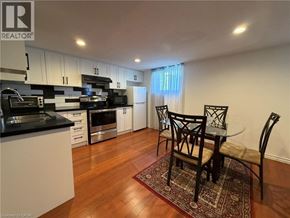 Stoney Creek apartment for rent - A kitchen with a table and chairs in the middle of the room.