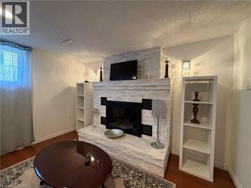 Stoney Creek apartment for rent - A living room with a fireplace and a television above it.