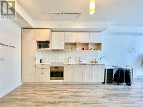 Toronto (Henry Farm) condo for rent - A kitchen with wooden cabinets and a white backsplash.