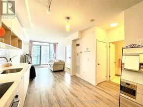 Toronto (Henry Farm) condo for rent - A well-lit kitchen with wooden floors and a large island.