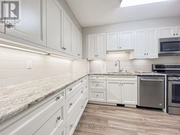 London South (South Y) townhouse for rent - A kitchen with white cabinets and a marble countertop.