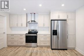 Russell townhouse for rent - A kitchen with white cabinets and a stainless steel refrigerator.