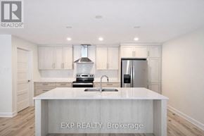 Russell townhouse for rent - A kitchen with white cabinets and a white island with EXP Realty Brokerage in the middle.