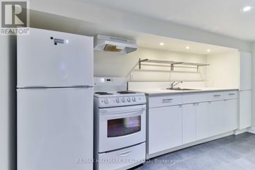 Toronto (Dovercourt-Wallace Emerson-Junction) apartment for rent - A white kitchen with a refrigerator, oven, and cabinets.