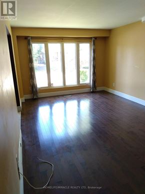 Hamilton (Gourley) apartment for rent - A room with wooden floors and a large window with curtains.