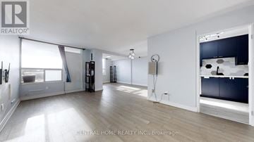 Toronto (Flemingdon Park) condo for rent - A spacious room with a large window and a kitchen area with a sink and stove.