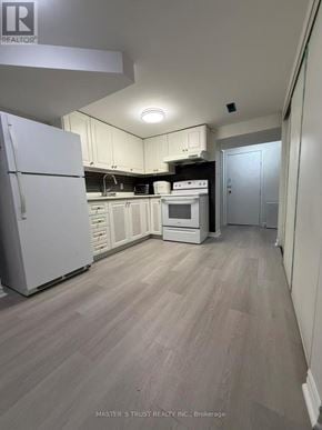 Toronto (Tam O'shanter-Sullivan) apartment for rent - A kitchen with white appliances and wooden floors.