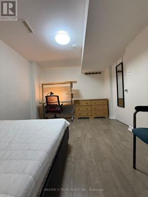 Toronto (Tam O'shanter-Sullivan) apartment for rent - A bedroom with a bed, dresser, and chair.