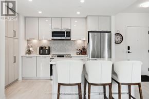 Innisfil condo for rent - A modern kitchen with white cabinets and appliances.