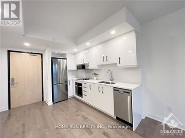 Ottawa condo for rent - A kitchen with white cabinets and stainless steel appliances.