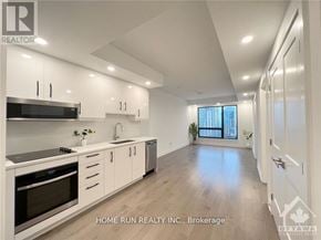 Ottawa condo for rent - A modern kitchen with white cabinets and stainless steel appliances.