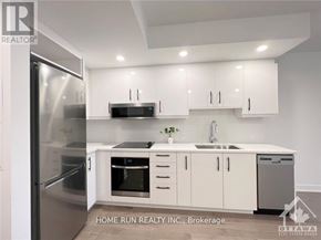 Ottawa condo for rent - A modern kitchen with white cabinets and stainless steel appliances.