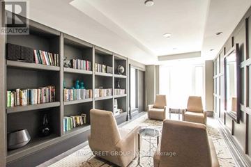 Toronto (Yonge-Eglinton) condo for rent - A living room with a bookshelf filled with books and a coffee table in the center.