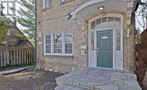 London East (East F) fourplex for rent - A house with a green door and a stone pathway leading to it.