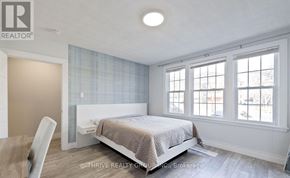 London East (East F) fourplex for rent - A bedroom with a bed, chair, and window.