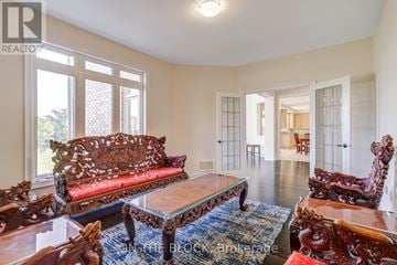 Whitchurch-Stouffville (Ballantrae) apartment for rent - A living room with a red sofa and wooden chairs.