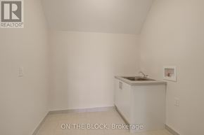 Whitchurch-Stouffville (Ballantrae) apartment for rent - A small white kitchen with a sink and a cabinet.
