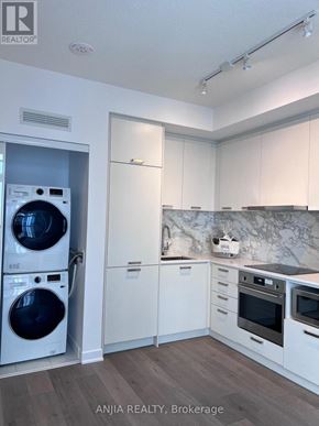 Vaughan (Vaughan Corporate Centre) condo for rent - A modern kitchen with a washer and dryer built in.