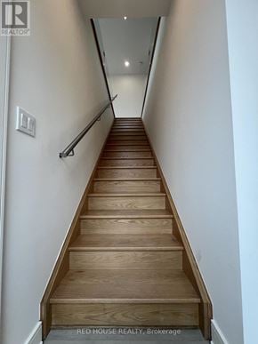 St. Catharines (Oakdale) townhouse for rent - A long flight of wooden stairs leads to a light at the end.