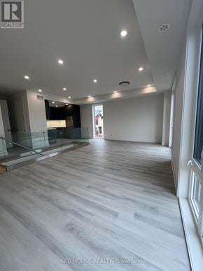 St. Catharines (Oakdale) townhouse for rent - A spacious room with wooden flooring and a glass partition.
