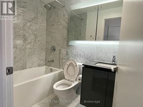 Toronto (Bayview Village) condo for rent - A bathroom with a toilet, a bathtub, and a mirror.