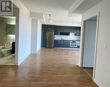 Toronto (Bayview Village) condo for rent - A realtor photo of a kitchen and living room with wood floors.