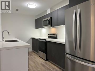 Windsor condo for rent - A kitchen with a stainless steel refrigerator, microwave, and oven.