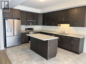Pelham (Fonthill) apartment for rent - A kitchen with a refrigerator, microwave, oven, sink, and cabinets.