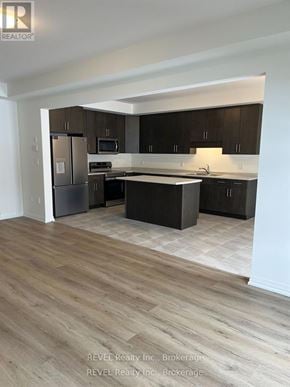 Pelham (Fonthill) apartment for rent - A kitchen with dark wood cabinets and a light wood floor.