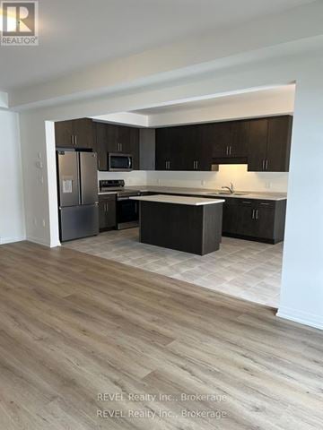 Pelham (Fonthill) apartment for rent - A kitchen with dark wood cabinets and a light wood floor.