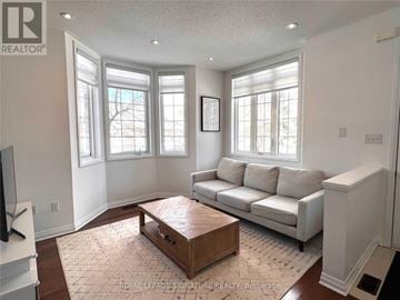Toronto (Clairlea-Birchmount) townhouse for rent - A living room with a white couch and a wooden coffee table.