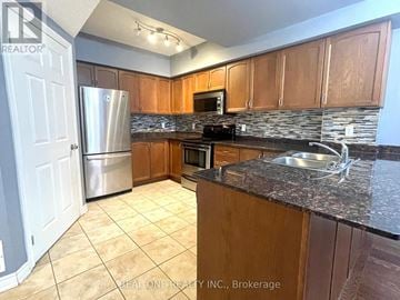 Hamilton (Central) condo for rent - A kitchen with wooden cabinets and granite countertops.