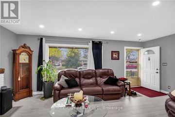 London South (South J) apartment for rent - A living room with a brown leather couch and a wooden grandfather clock.
