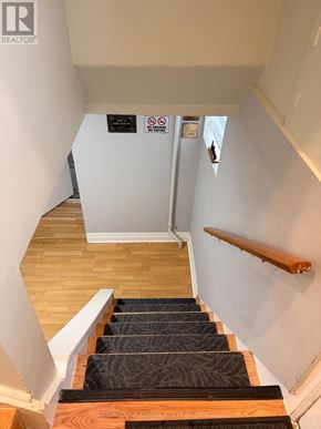 Toronto (Newtonbrook West) apartment for rent - A staircase with a wooden handrail and a sign on the wall.