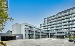 Toronto (Bayview Village) condo for rent - A modern multi-story building with glass windows and a parking lot in front.