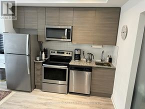 Toronto (Bayview Village) condo for rent - A modern kitchen with stainless steel appliances and wooden cabinets.