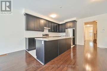 Brampton (Northwest Brampton) townhouse for rent - A kitchen with dark wood cabinets and a white island.