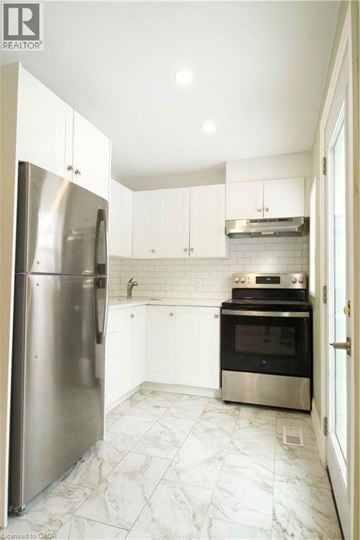 London apartment for rent - A kitchen with a refrigerator, oven, and stove.