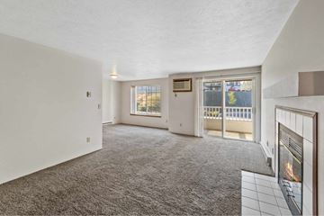 Spokane apartment for rent - A living room with a grey carpet and a fireplace.