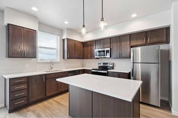 Post Falls apartment for rent - A modern kitchen with dark wood cabinets and stainless steel appliances.