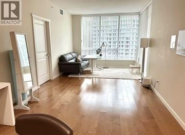 Vancouver apartment for rent - A living room with a brown leather couch and wooden floors.