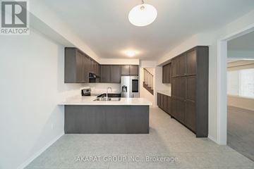 Thorold (Hurricane/Merrittville) apartment for rent - A modern kitchen with dark brown cabinets and a central island.